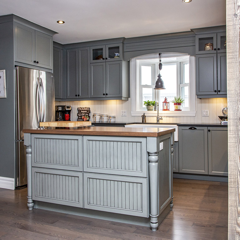 Cuisines Beauregard |Rustic grey green kitchen with an antique finish black granite countertop